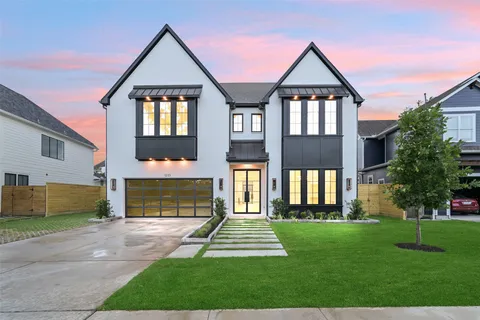 a front view of a house with a yard and garden