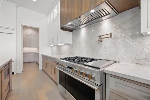 a large kitchen with a large counter top stainless steel appliances and cabinets