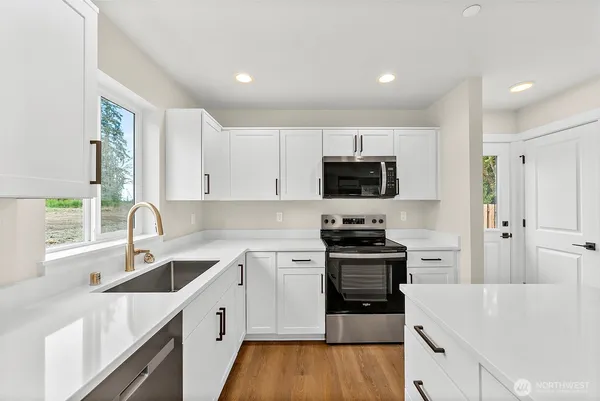 a kitchen with a sink stove top oven and refrigerator