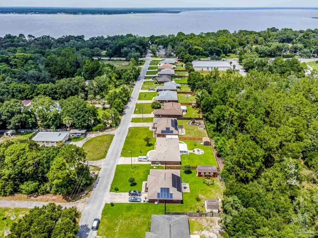 a view of a large yard with swimming pool and garden