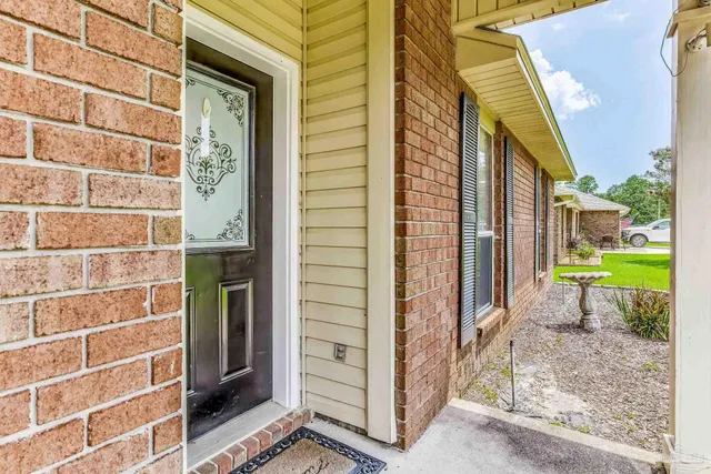 a view of a brick house with a large door and a large window
