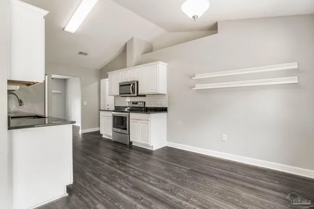 a kitchen with granite countertop a refrigerator and a stove