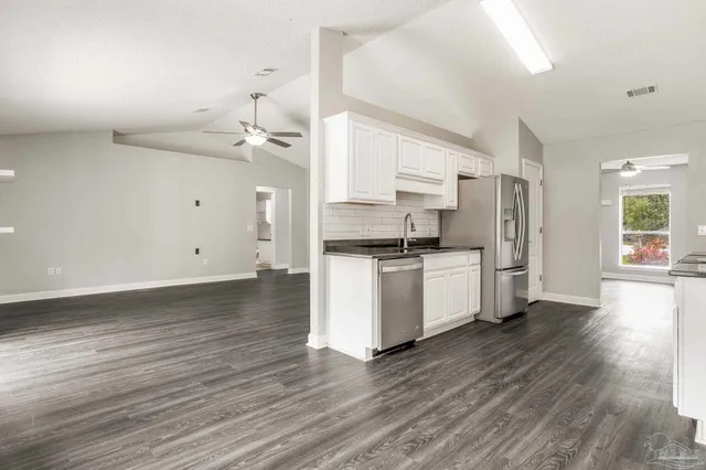 a kitchen with a refrigerator and white cabinets
