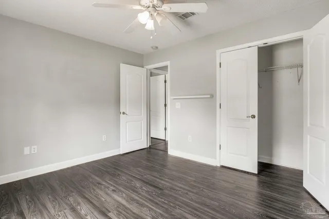 an empty room with wooden floor and closet area