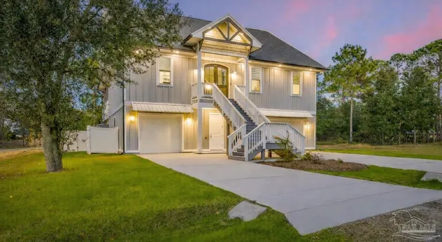 a view of a big house with a big yard and large trees