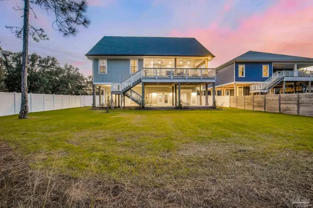 a view of a house with a big yard and a large tree