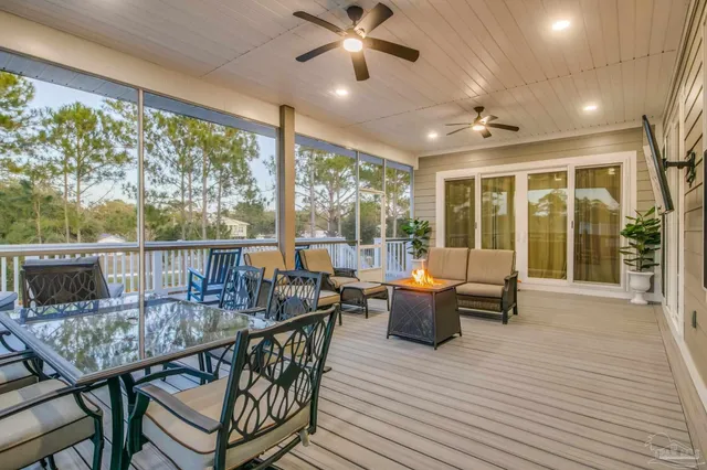 a living room with stainless steel appliances furniture wooden floor and a large window