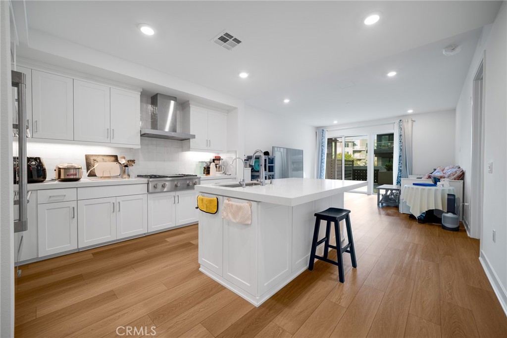 a kitchen with white cabinets and sink