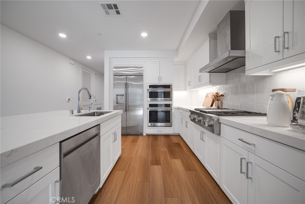 2202 Rivington Irvine, CA 92612 - Photo 6 of 21 a large kitchen with stainless steel appliances granite countertop a lot of counter space and wooden floor