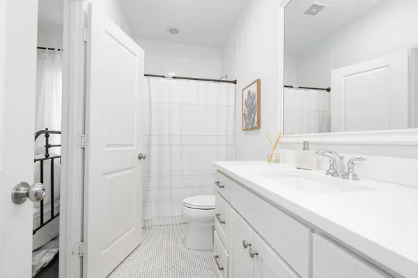 a bathroom with a sink a toilet and shower