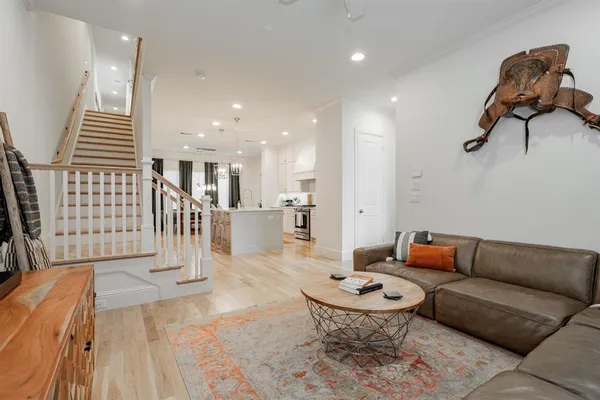 a living room with furniture a rug and kitchen view