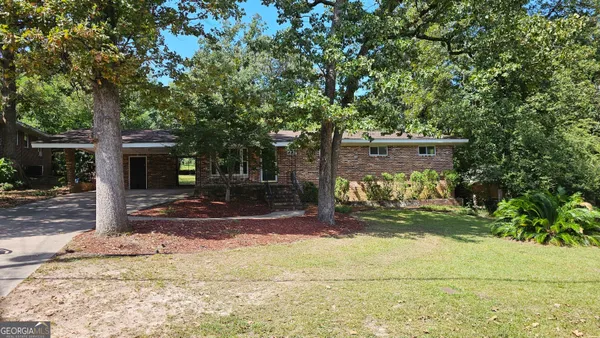a view of a house with backyard and tree