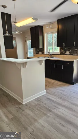 a kitchen with a sink cabinets and wooden floor