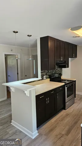 a kitchen with stainless steel appliances granite countertop a sink a stove and a refrigerator