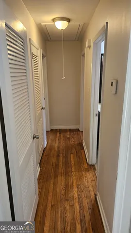 a view of a hallway with wooden floor and staircase
