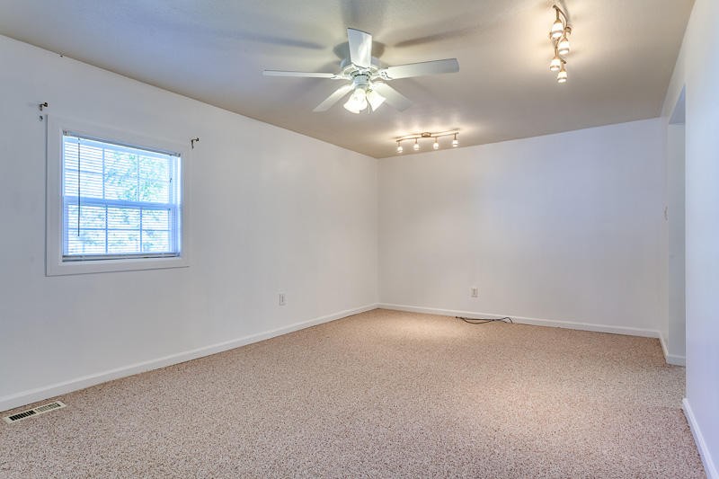 106 Hamilton Circle Oak Ridge, TN 37830 - Photo 25 of 36 an empty room with a chandelier fan and windows