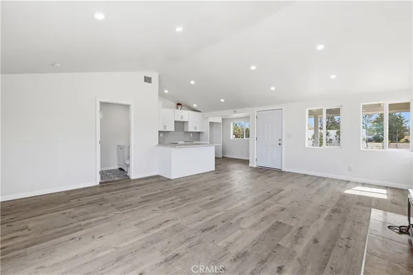 a view of empty room with wooden floor and window