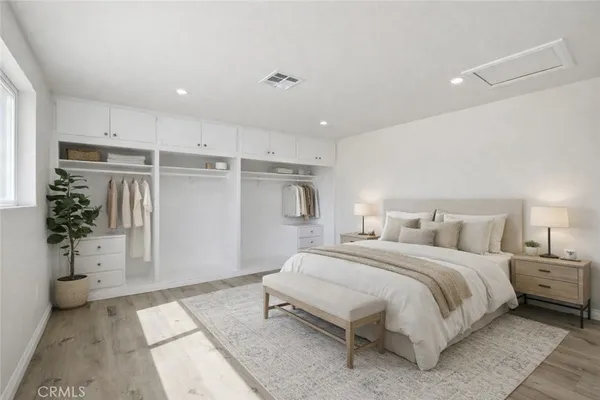 a bedroom with a large bed and a potted plant
