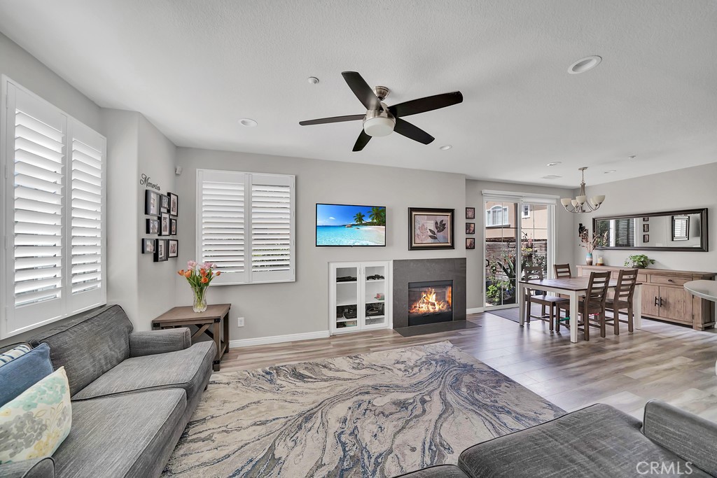 12 Geranium Irvine, CA 92618 - Photo 6 of 20 a living room with furniture a fireplace and a flat screen tv with kitchen view