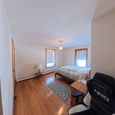 a bedroom with a bed and wooden floor