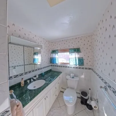 a bathroom with a granite countertop toilet sink and mirror