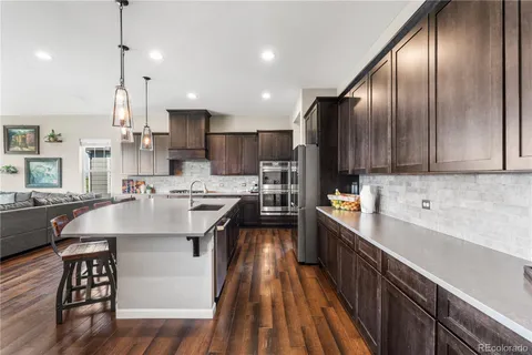 a kitchen with stainless steel appliances granite countertop a sink a stove and a refrigerator