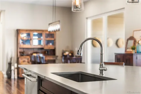 a kitchen with a sink a counter and chairs