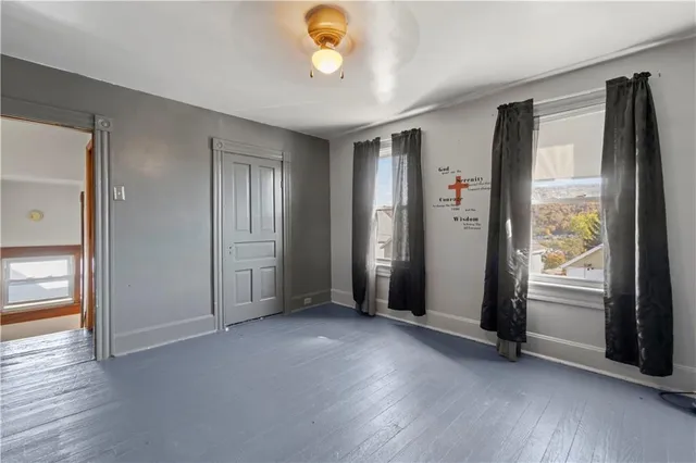 an empty room with windows and closet