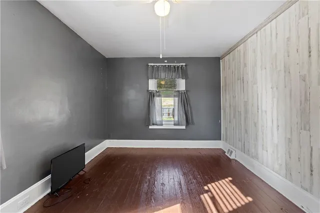 a view of a room with wooden floor and a window