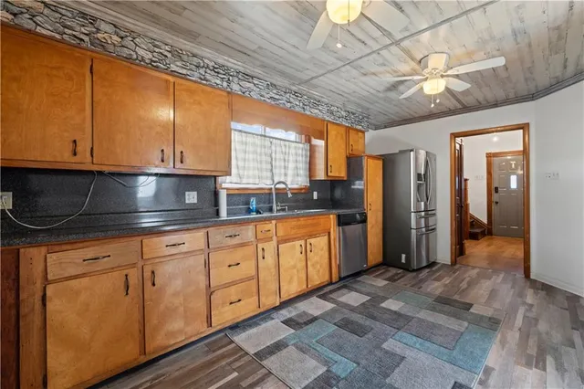 a kitchen with stainless steel appliances granite countertop a sink a stove cabinets and wooden floor