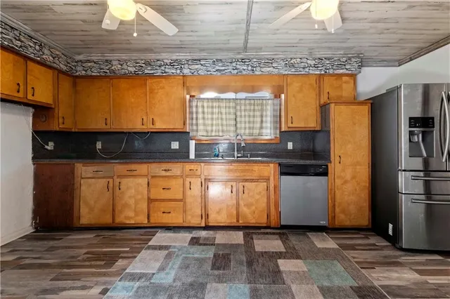 a kitchen with stainless steel appliances granite countertop a stove a sink and a refrigerator