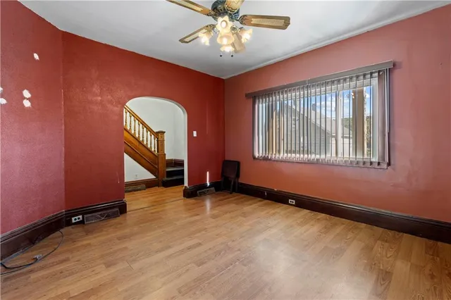 an empty room with windows and ceiling fan