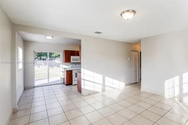 a view of a kitchen with furniture and an empty room