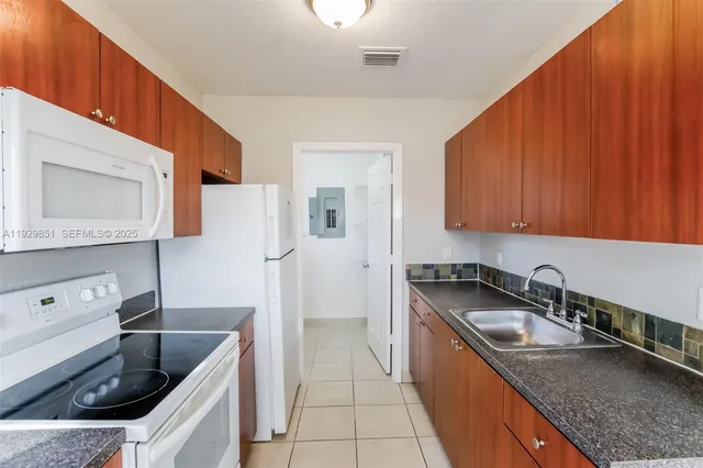 a kitchen with a sink stove top oven and cabinets