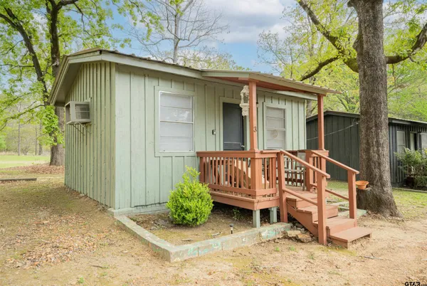 a view of a house with a yard and wooden fence