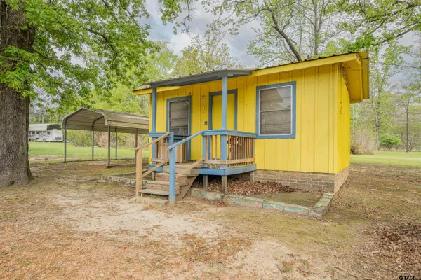a backyard of a house with table and chairs