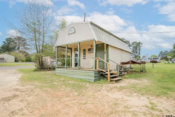 a view of a house with a yard and sitting area