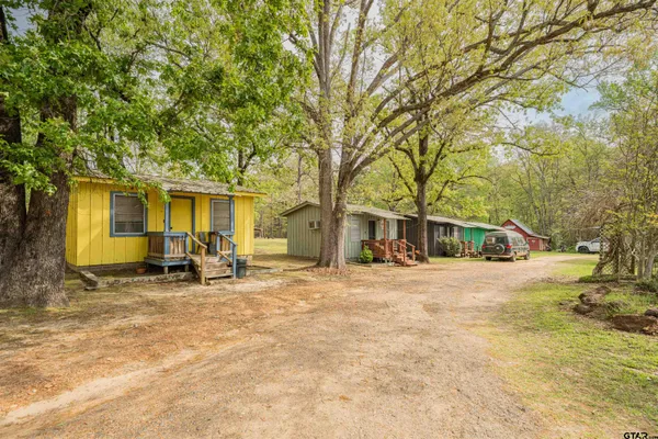 a view of a house with backyard and trees