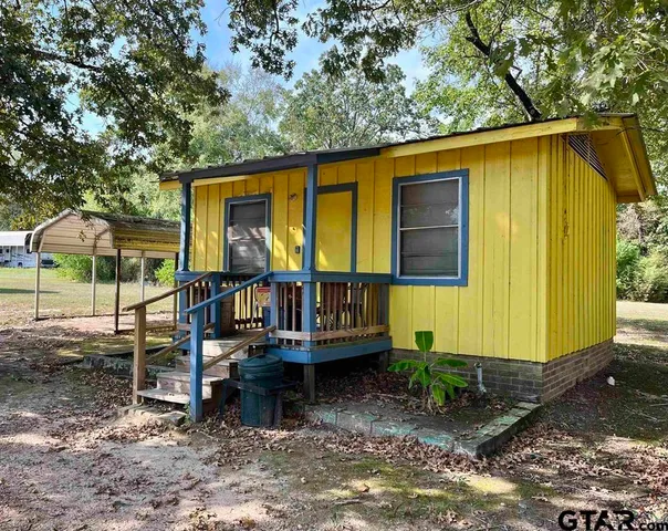 a view of a house with backyard and porch