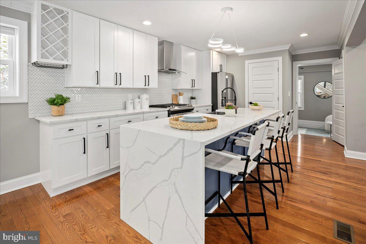 111 Sunnyside Road Silver Spring, MD 20910 - Photo 13 of 44 a kitchen with stainless steel appliances granite countertop a stove a sink a dining table and chairs with wooden floor