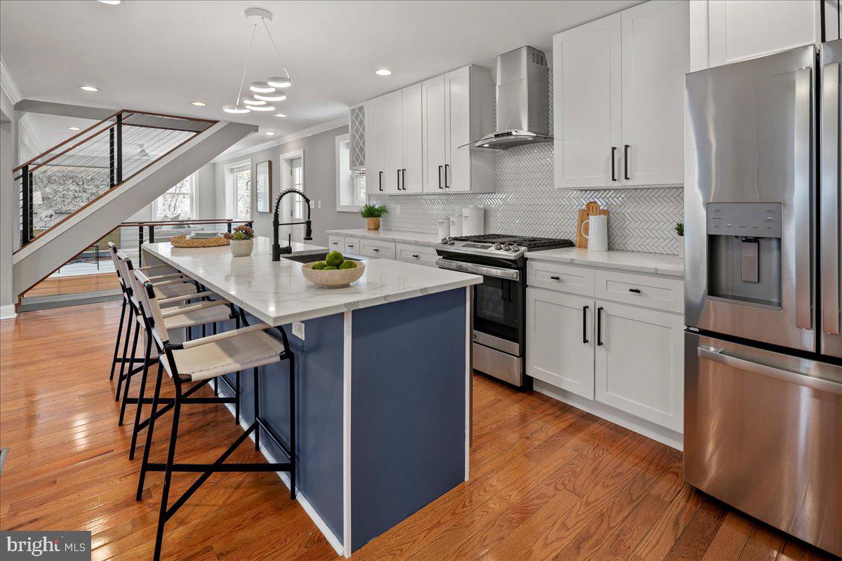 111 Sunnyside Road Silver Spring, MD 20910 - Photo 16 of 44 a kitchen with stainless steel appliances kitchen island a refrigerator and wooden floor