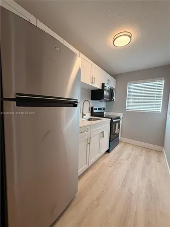 a kitchen with stainless steel appliances a refrigerator sink and microwave