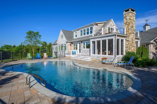 a view of a house with pool and sitting area