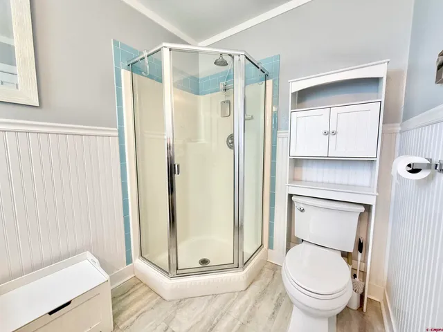 an empty room with wooden floor closet and windows
