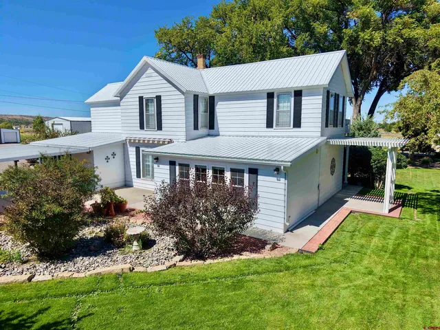 a front view of a house with a yard and potted plants