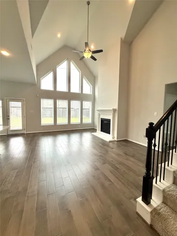 a view of an empty room with wooden floor fireplace and a window