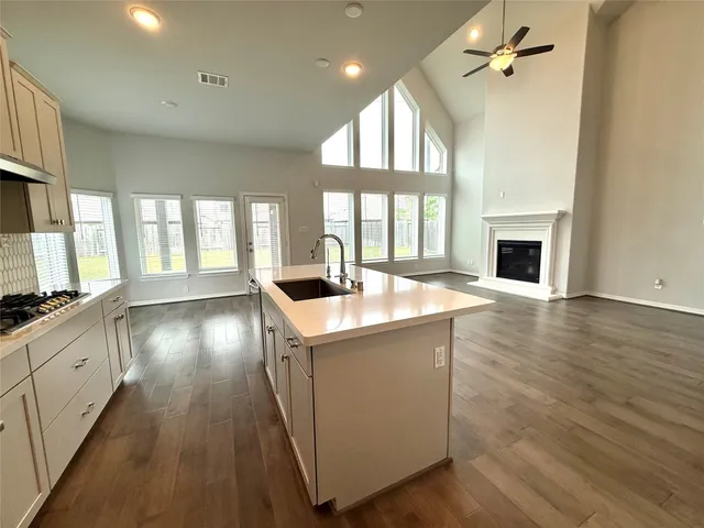 a kitchen with stainless steel appliances granite countertop a stove and a wooden floors