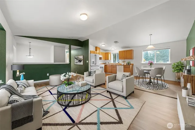 a living room with furniture and a dining table with kitchen view