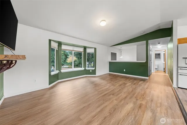 a view of a livingroom with wooden floor and a flat screen tv