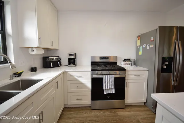 a kitchen with white cabinets and stainless steel appliances